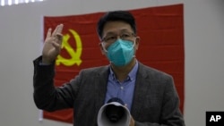 Dr. Zhang Junjian, former head of one of three temporary coronavirus hospitals, speaks to journalist near a Chinese Communist party flag in Wuhan, central China's Hubei province, Thursday, April 9, 2020. Released from their apartments after a 2 1/2…