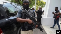 Un guardia de seguridad vigila mientras el nuevo primer ministro haitiano, Garry Conille, abandona su ceremonia de juramento en Puerto Príncipe, Haití, el lunes 3 de junio de 2024.