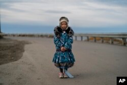 Dressed in an Inuit-style parka, Annsoph Nayokpuk, 6, stands for a photo in Shishmaref, Alaska, Wednesday, Oct. 5, 2022. (AP Photo/Jae C. Hong)