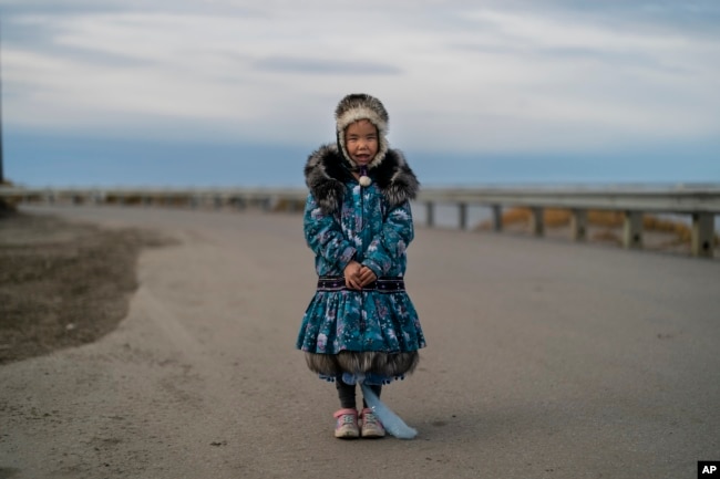 Dressed in an Inuit-style parka, Annsoph Nayokpuk, 6, stands for a photo in Shishmaref, Alaska, Wednesday, Oct. 5, 2022. (AP Photo/Jae C. Hong)