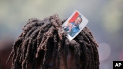 A supporter of former Haitian President Jean-Bertrand Aristide looks into the camera as he waits with others near the airport for his expected arrival from Cuba, where he underwent medical treatment, in Port-au-Prince, July 16, 2021. 