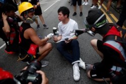 FILE - Roy Kwong reacts after the tear gas and pepper spray was used by a police during a protest against the Yuen Long attacks in Yuen Long, New Territories, Hong Kong, China, July 27, 2019.