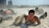 A paramilitary policeman crawls with his comrades in the sand during heat endurance training in Hefei, Anhui province, China. The temperature in Hefei reached 39 degrees Celsius (102.2 degrees Fahrenheit).