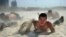 A paramilitary policeman crawls with his comrades in the sand during heat endurance training in Hefei, Anhui province, China. The temperature in Hefei reached 39 degrees Celsius (102.2 degrees Fahrenheit).