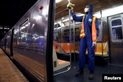 FILE - A worker wipes down surfaces as the MTA Subway closed overnight for cleaning and disinfecting during the outbreak of the coronavirus disease (COVID-19) in the Brooklyn borough of New York City, May 7, 2020.