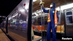 A worker wipes down surfaces as the MTA Subway closed overnight for cleaning and disinfecting during the outbreak of the coronavirus disease (COVID-19) in the Brooklyn borough of New York City, May 7, 2020. 