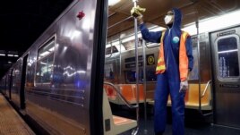 FILE - A worker wipes down surfaces as the MTA Subway closed overnight for cleaning and disinfecting during the outbreak of the coronavirus disease (COVID-19) in the Brooklyn borough of New York City, May 7, 2020.