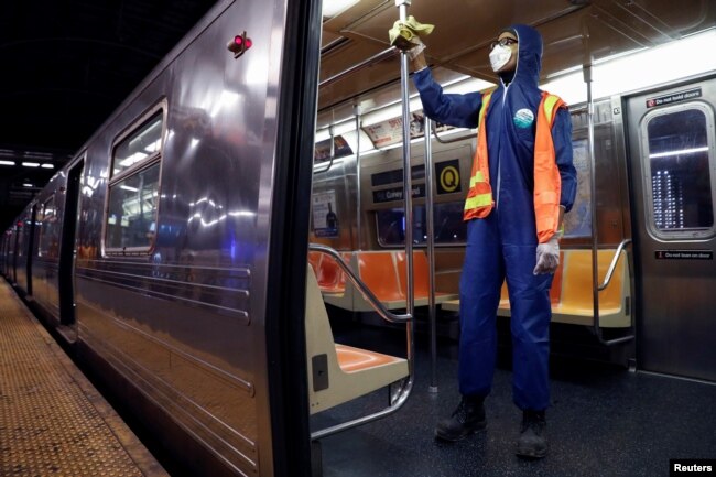 FILE - A worker wipes down surfaces as the MTA Subway closed overnight for cleaning and disinfecting during the outbreak of the coronavirus disease (COVID-19) in the Brooklyn borough of New York City, May 7, 2020.
