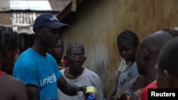 Một nhân viên của UNICEF chia sẻ thông tin với cư dân ở Conakry, Guinea về Ebola và những phương pháp tốt nhất để ngăn ngừa sự lan tràn của căn bệnh này.