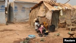 FILE - A woman takes care of her child in a camp sheltering internally displaced people (IDPs) next to the M'Poko international airport in Bangui, Central African Republic, Feb. 13, 2016. 