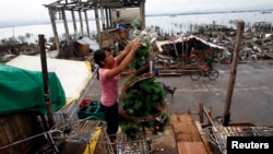 Nora Yara, a victim of super typhoon Haiyan, decorates a Christmas tree.