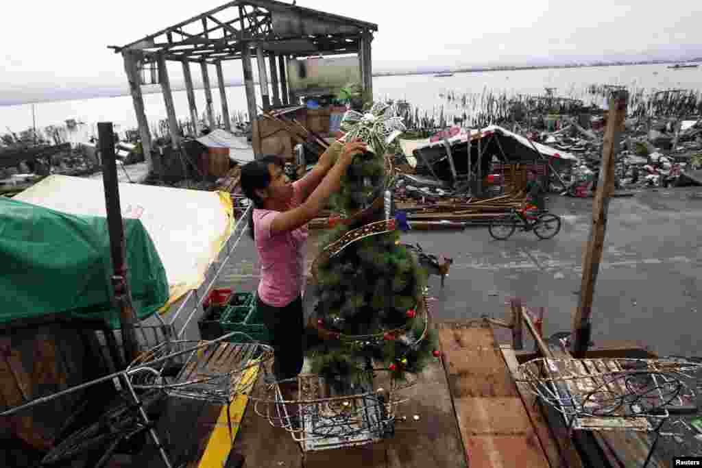 Nora Yara, a victim of Super Typhoon Haiyan, decorates a Christmas tree along a devastated area of Sagkahan town, Tacloban city, central Philippines. 