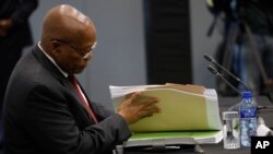 L'ancien président sud-africain Jacob Zuma examine des documents lors de sa déposition devant une commission d'État enquêtant sur de nombreuses allégations de corruption au sein du gouvernement et d'entreprises appartenant à l'État, à Johannesburg, en Afrique du Sud, le 17 juille