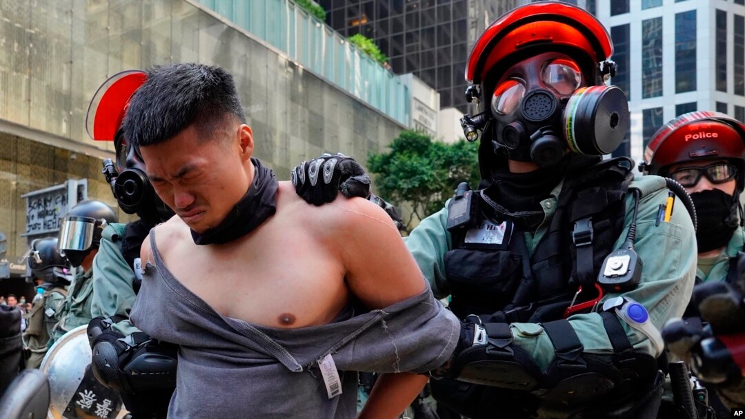 A protester is detained in Central district of Hong Kong on Monday, Nov. 11, 2019. A Hong Kong protester was shot by police Monday in a dramatic scene caught on video as demonstrators blocked train lines and roads during the morning commute.