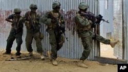 FILE - Somali soldiers search through homes for al-Shabaab fighters, during an operation in Ealsha Biyaha, Somalia, June, 2, 2012. On Tuesday, Somali forces attacked a base of the militant group north of Kismayo.