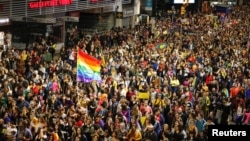 FILE - Members of the lesbian, gay, bisexual and transgender (LGBT) community and residents participate in the annual Diversity March in downtown Montevideo, Uruguay, Sept. 28, 2018. 