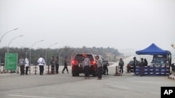A vehicle convoy carrying a lawmaker passes through a checkpoint near the parliament building in Naypyitaw, Jan 30 2011