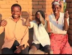 Talandira jokes around with his parents. (Lameck Masina/VOA)