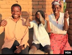 Talandira jokes around with his parents. (Lameck Masina/VOA)