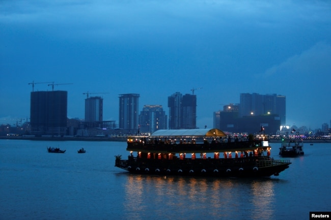 FILE - A boat passes buildings under construction on Diamond Island also known as "Koh Pich," as seen from Tonle Chaktomuk River in Phnom Penh, Cambodia, May 22, 2018.