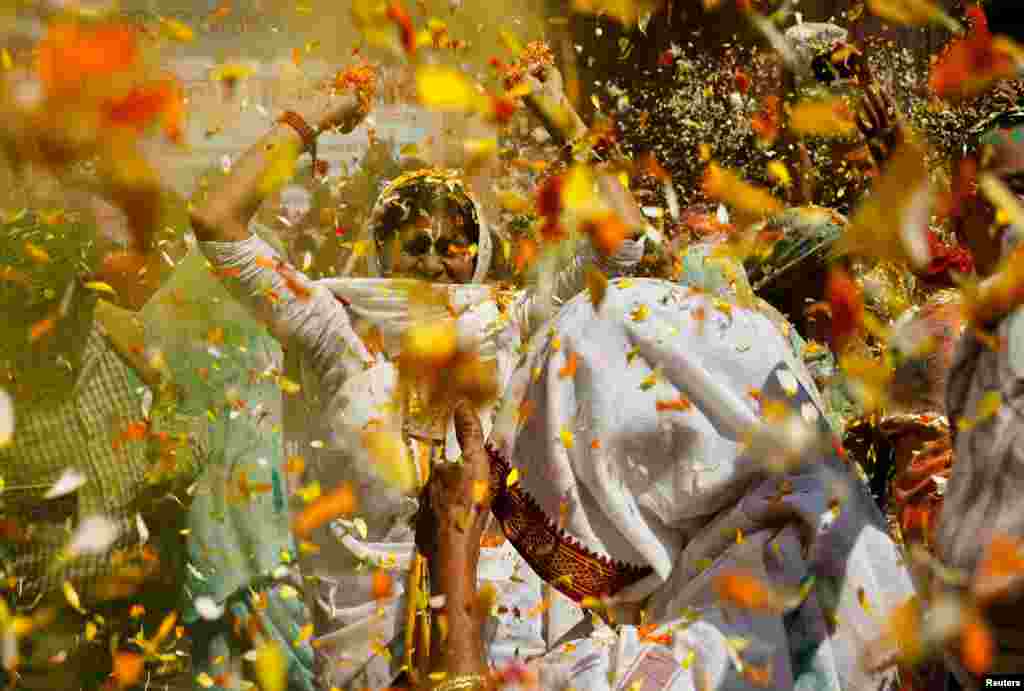 Widows dance as they take part in Holi celebrations inside a temple in Vrindavan, in the northern state of Uttar Pradesh, India.