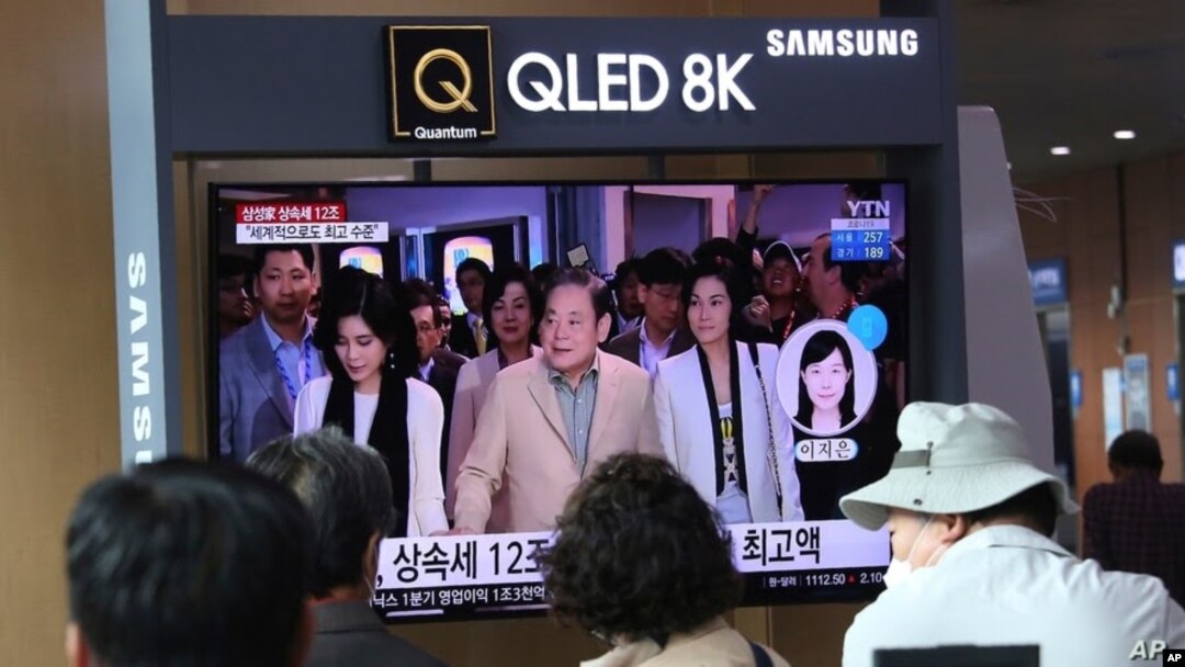 Personas observan una pantalla en la que se muestra una foto del difunto líder de Samsung, Lee Kun Hee, junto a sus hijas. [Foto de archivo]