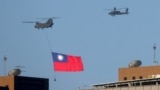 Un helicóptero pasea una bandera de Taiwán durante los ensayos para una fiesta nacional en Taipei el 5 de octubre de 2021. 