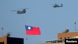 Un helicóptero lleva una bandera de Taiwán durante los ensayos para una fiesta nacional en Taipei el 5 de octubre de 2021. 