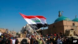 Army soldiers try to prevent anti-government protesters from crossing the al- Shuhada (Martyrs) bridge in central Baghdad, Iraq, Nov. 6, 2019. 