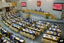 Russian lawmaker Olga Batalina, at the podium, addresses members of the Duma (lower parliament house) in Moscow, Russia, Jan. 25, 2017. Last month the Duma voted overwhelmingly to eliminate criminal liability for battery on family members that does not cause bodily harm.