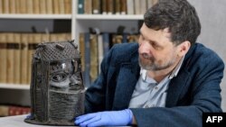 FILE - A picture taken on March 17, 2021 at the University of Aberdeen shows Neil Curtis, Head of Museums and Special Collections posing by a bronze sculpture depicting an "Oba" (king) of Benin acquired by the University at auction in 1957.