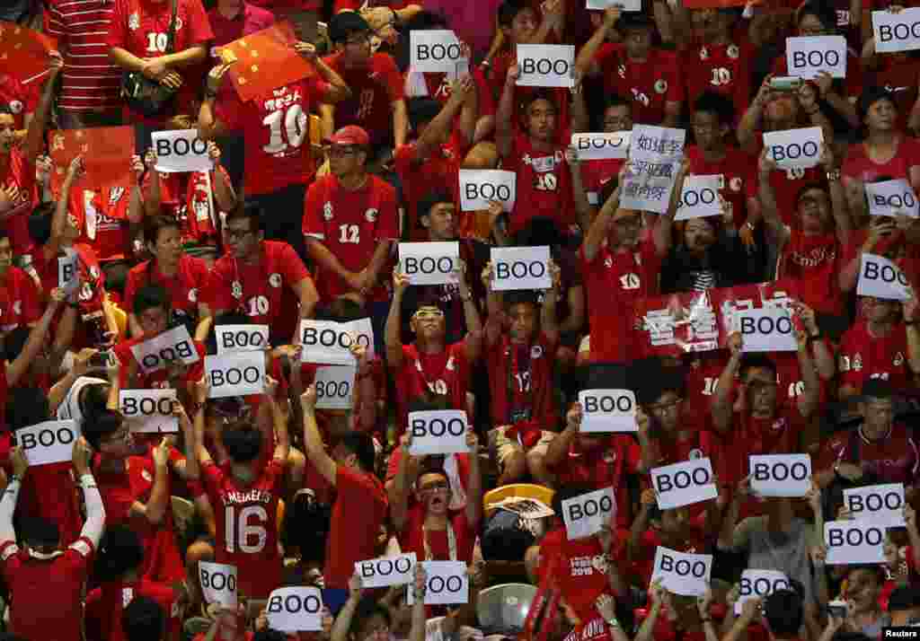 Torcedores de Hong Kong seguram placas que indicam vaias no jogo entre Hong Kong e China, em Hong Kong, nas eliminatórias para o Mundial de 2018.