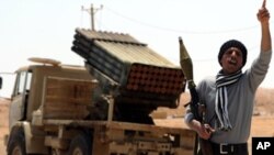 A Libyan rebel fighter shouts slogans as he welcomes comrades heading towards the front line outside the Libyan eastern city Ajdabiya on May 10, 2011.