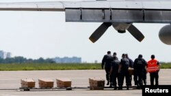 Peti-peti berisi jenazah para korban penembakan jatuh pesawat Malaysia Airlines MH17 di Ukraina yang akan diterbangkan ke Belanda dari bandara Kharkiv (22/7).