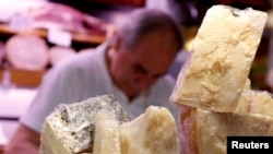 Italian Parmesan, right, and Pecorino Romano cheese are displayed on a counter at a deli in Rome, Italy, Oct. 3, 2019.