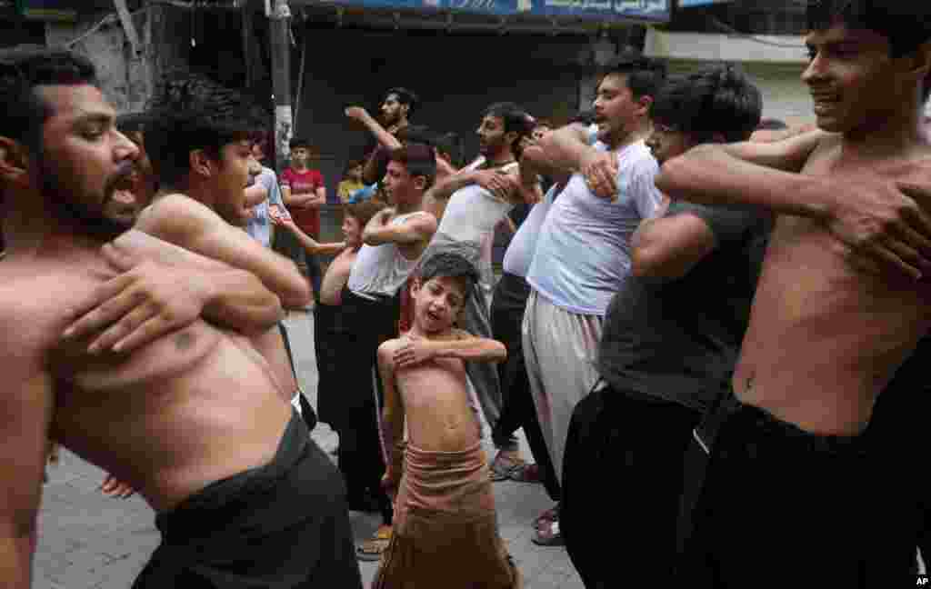 A Shi&#39;ite Muslim boy beat his chest with others during a Muharram procession, in Lahore, Pakistan.
