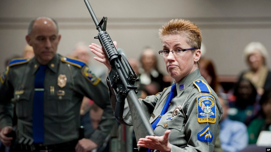 FILE -Firearms training unit Detective Barbara J. Mattson, of the Connecticut State Police, holds a Bushmaster AR-15 rifle, the same make and model used by Adam Lanza in the 2012 Sandy Hook School shooting, in this Jan. 28, 2013 photo.