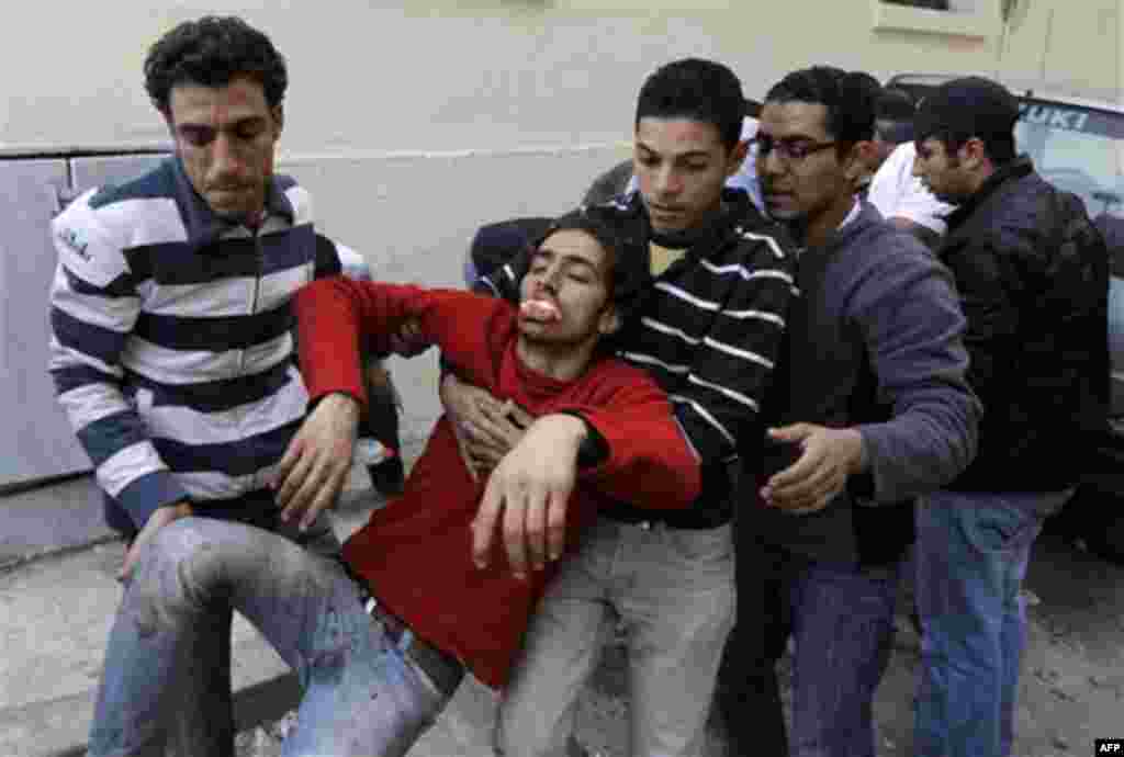 Anti-government protestors evacuate a wounded man during clashes in Cairo, Egypt, Thursday, Feb. 3, 2011. Egypt's prime minister apologized for an attack by government supporters on protesters in a surprising show of contrition Thursday, and the governmen