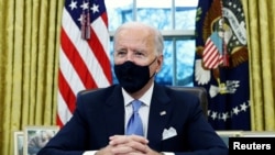 Presidente Joe Biden assinou várias ordens executivas após tomada de posse, no Salão Oval da Casa Branca, Washington DC, 20 Janeiro 2021