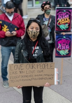 People participate at a rally "Love Our Communities: Build Collective Power" to raise awareness of anti-Asian violence outside the Japanese American National Museum in Little Tokyo in Los Angeles Saturday, March 13, 2021.
