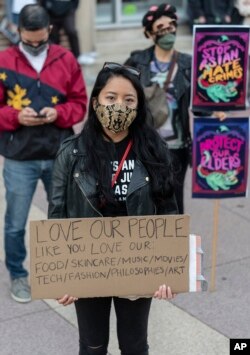 People participate at a rally "Love Our Communities: Build Collective Power" to raise awareness of anti-Asian violence outside the Japanese American National Museum in Little Tokyo in Los Angeles Saturday, March 13, 2021.