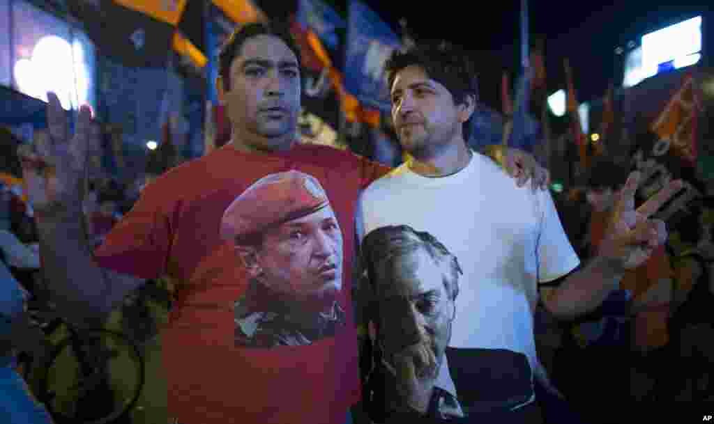 Argentine supporters of Venezuelan President Hugo Chavez pose for pictures wearing T-shirts with images of Chavez, left, and Argentina&#39;s late President Nestor Kirchner, right, in Buenos Aires, Argentina, March 5, 2013.