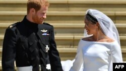 FILE - Britain's Prince Harry, Duke of Sussex and his wife Meghan, Duchess of Sussex leave from the West Door of St George's Chapel, Windsor Castle, in Windsor, on May 19, 2018 after their wedding ceremony. 