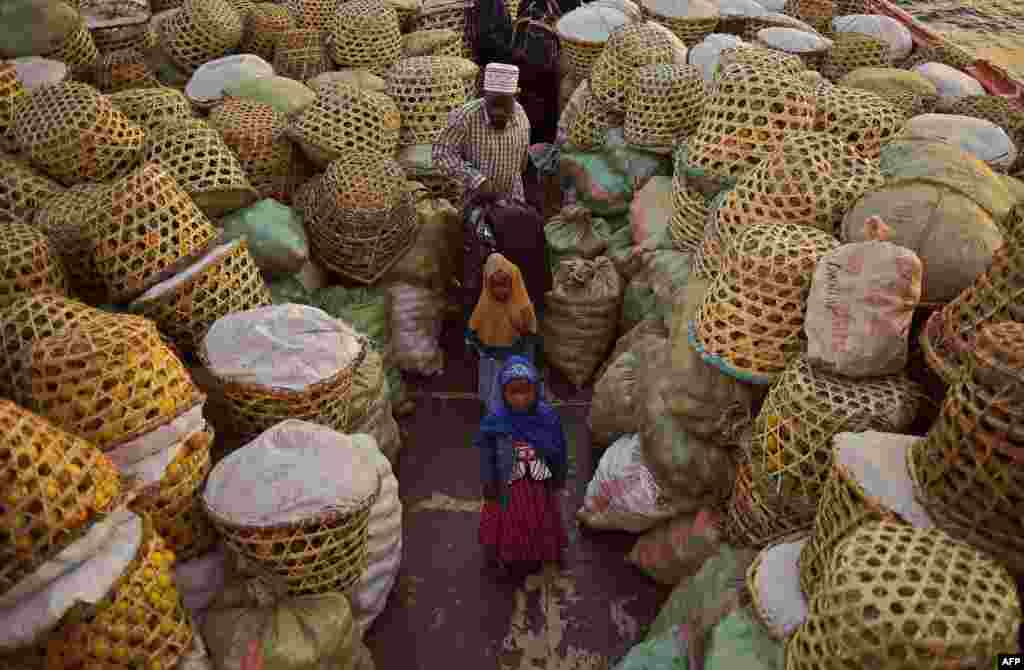 A muslim family board a ferry loaded with baskets of oranges on Ukerewe Island, Lake Victoria.