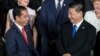 Presiden Joko Widodo berbincang dengan Presiden China Xi Jinping saat foto bersama pada KTT G20 di Osaka, 28 Juni 2019. (Foto: AFP)