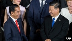 Presiden Joko Widodo berbincang dengan Presiden China Xi Jinping saat foto bersama pada KTT G20 di Osaka, 28 Juni 2019. (Foto: AFP)