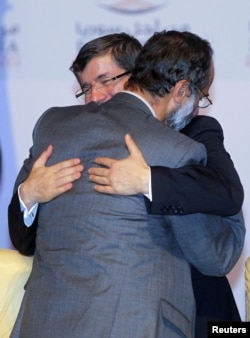 Turkish FM Ahmet Davutoglu congratulates new Syrian National Coalition head Mouaz al-Khatib during the Meeting of the General Assembly of the Syrian National Council in Doha, Qatar, November 11, 2012.