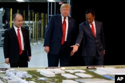 El presidente Donald Trump hace un recorrido por Foxconn con el presidente de la empresa, Terry Gou, a la derecha, y el CEO de SoftBank, Masayoshi Son, el 28 de junio de 2018, en Mt. Pleasant, Wisconsin.