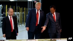 FILE - President Donald Trump takes a tour of Foxconn with Foxconn chairman Terry Gou, right, and CEO of SoftBank, Masayoshi Son, June 28, 2018, in Mt. Pleasant, Wisconsin.