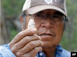 In this June 22, 2016, photo, Jonah Yellowman, a Navajo spiritual adviser, holds a arrowhead found laying on the ground in Kane Gulch, near Blanding, Utah.